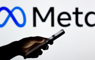 Meta logo behind person using their phone
